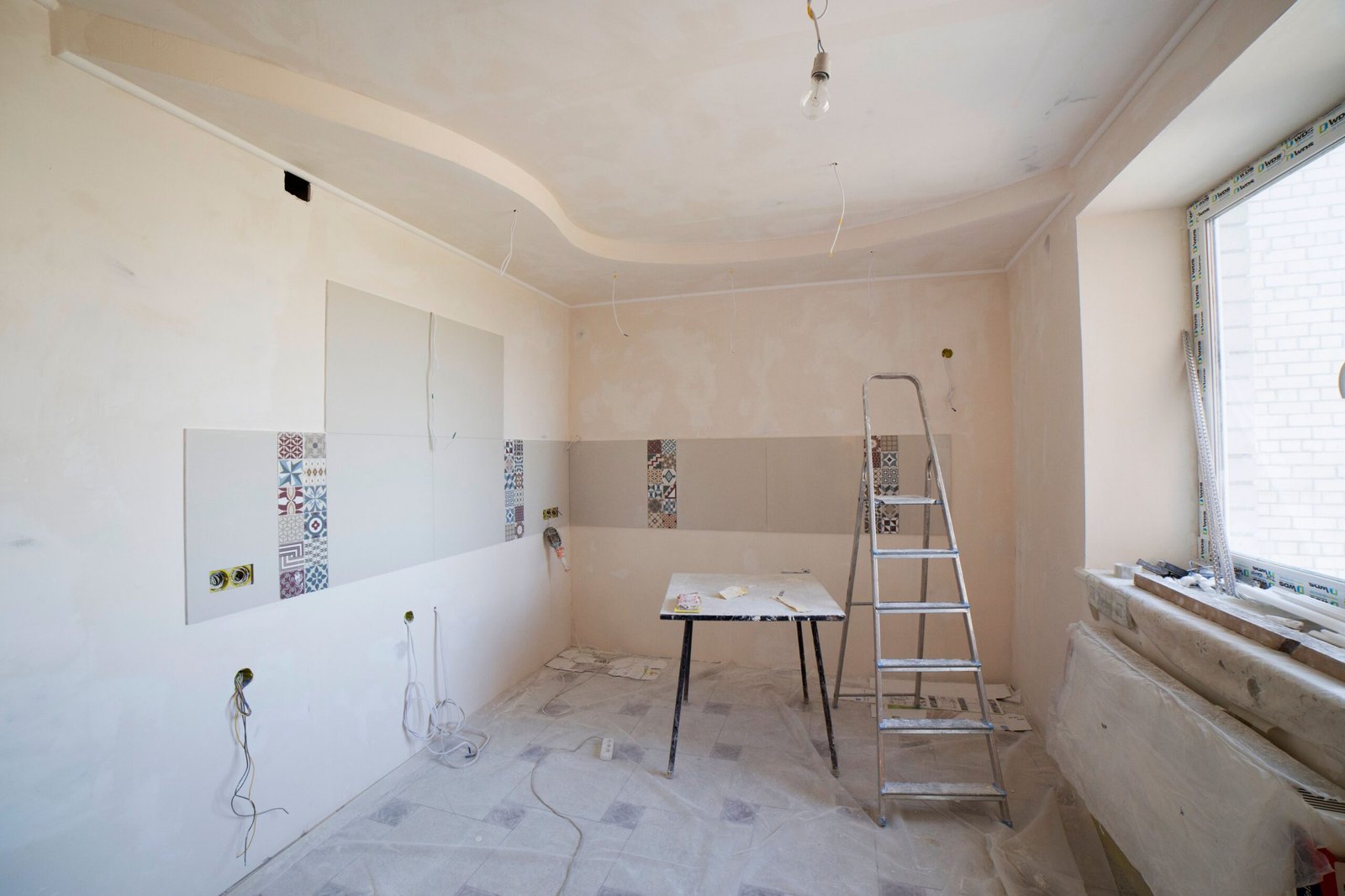 Services Spacious kitchen under renovation with ladder and tools, showcasing a fresh new design.