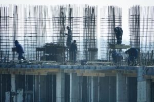 pexels photo 30832160 30832160 Construction workers at a high-rise building site with visible steel reinforcements.